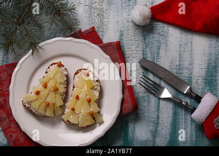 Neue-Sandwiches mit Käse, Ananas und Krabben stiks in der Form eines Weihnachtsbaums und mit sanddornbeeren eingerichtet, befinden sich auf einem Stockfoto