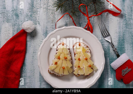 Neue-Sandwiches mit Käse, Ananas und Krabben stiks in der Form eines Weihnachtsbaums und mit sanddornbeeren eingerichtet, befinden sich auf einem Stockfoto