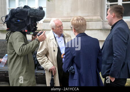 David Dimbleby, britischer Journalist und ehemaliger Moderator der Fragestunde Programm der BBC, vor dem Parteitag der Konservativen Partei, 2019 in Manchester, UK gesehen, interviewen zwei junge Männer. Stockfoto