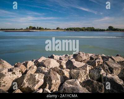 Diffuse Binnenschiff auf Ruhe Rhein mit Rocky bank Notunterstände im und Sandstrand in der Ferne Stockfoto