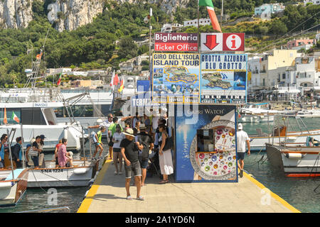 Insel CAPRI, ITALIEN - AUGUST 2019: Menschen, die nach einem Ausflug zum Meer vom Hafen auf der Insel Capri aus von einem kleinen Boot im Hafen abfahren Stockfoto