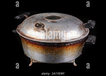 Alte elektrische Kochgeschirr aus Aluminium. Küche Zubehör in Mitteleuropa verwendet. Der dunkle Hintergrund. Stockfoto