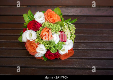 Auf eine romantische Hochzeit Koralle, roter und weißer Blumenstrauß ruht auf auf einer Bank in der Nähe. bridal Konzept. selektive Fokus, niemand Stockfoto