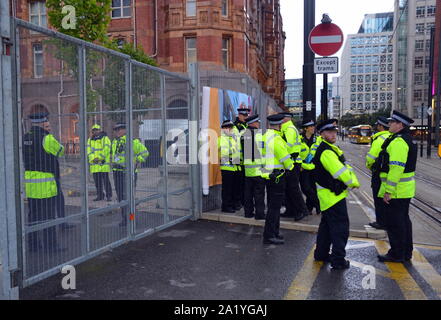 Polizei warten für die wagenkolonne des Ministerpräsidenten auf dem Parteitag der Konservativen Partei 2019 in Manchester, Großbritannien, am 28. September zu kommen, beobachten die Demonstranten auf der anderen Straßenseite. Stockfoto