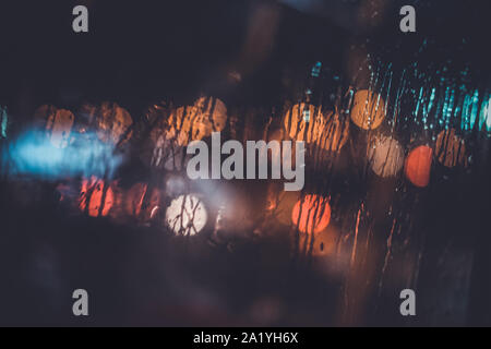 Ampel durch das Fenster in einer regnerischen Nacht Stockfoto