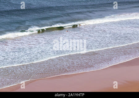 Surfer in den Wellen aus Mawgan Porth Beach, North Cornwall, Großbritannien Stockfoto