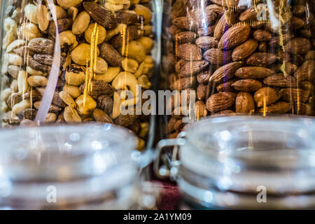 Verschiedene Arten von Nüssen und Samen in Glas Glas hautnah. Eine Vielzahl von Muttern in Gläsern. Stockfoto