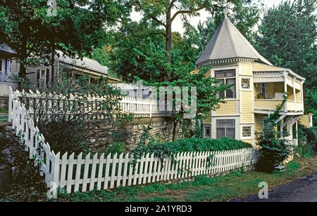 Manchmal genannt die Kleine Yallah Haus, diese ungewöhnliche Gelb - Holzhütte gemalt ist auf einer kleinen Menge zwischen zwei Straßen verkeilt und von einem weißen Lattenzaun in Eureka Springs, Arkansas, USA umgeben. Auch als die vollere Hütte genannt, es ist eines der am meisten fotografierten im Viktorianischen Stil Häuser in diesem malerischen Ozark Berge Stadt. Durch die Spring Street und King Street, das zweistöckige Haus im Jahr 1890 erbaut wurde und einfach durch sein Dach mit einem Maximum bei einem Ende identifiziert Flankiert Stockfoto