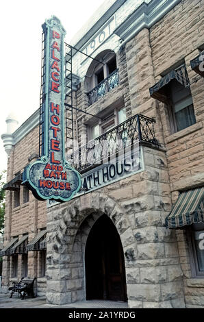 Eine Außenansicht des Palace Hotel und Bad Haus gebaut mit Bausteinen der lokalen Kalkstein in 1901 und immer noch Gäste in den Ozark Bergen Stadt Eureka Springs, Arkansas, USA. Das Wahrzeichen ist für seine ursprünglichen vertikalen Zeichen, dass er einer der ersten, der mit Neonlicht in den 1940er beleuchtet werden. Das historische Hotel bietet jetzt acht antik eingerichteten Suiten mit King-Size-Betten und Wasserstrahl Badewannen. Aber die Hauptattraktion ist der viktorianischen Badewanne Haus, wo Spa-besucher ein Mineralbad in der ursprünglichen Clawfoot Wannen genießen können. Stockfoto