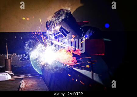 Motswana Schweißgerät Arbeiter in einer Botswana Workshop, Schweißen zwei Teile aus Metall Stockfoto