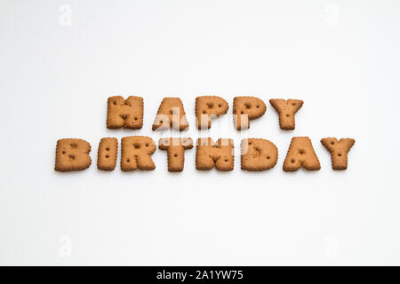 Die worte Happy Birthday durch braune Kekse gemacht auf die weiße Fläche im Querformat Stockfoto