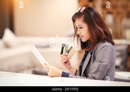 Schöne Geschäftsfrau Shopping und online Bezahlung mit Tablet- und Kreditkarten an Hand Stockfoto