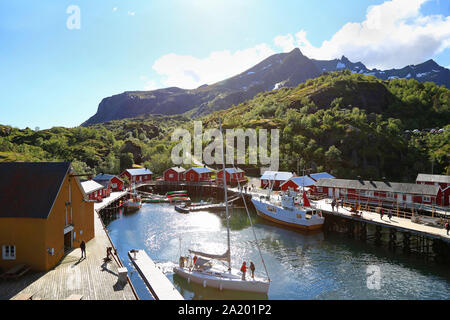 Nusfjord Hafen mit bunten roten Fischerhäuser und Segelboot in einem sonnigen Tag, Lofoten, Norwegen Stockfoto