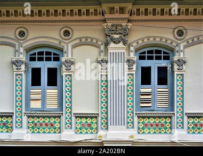 Alte Fenster mit blauem Fensterläden aus Holz und Chinesische Fliesen auf der Vorderseite des traditionellen Peranakan oder Straits Chinesischen shop Haus in Little India, Singapur Stockfoto