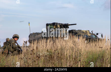 Ukrainische Soldaten vom 10. Berg Assault Brigade defensive Manöver mit US-Soldaten von Unternehmen D durchführen, 1. Bataillon, 26 Infanterie Regiment, 2. Brigade, Luftlandedivision (Air Assault), als Teil der Schnellen Trident 2019, Sept. 26, 2019, in der Nähe der Yavoriv, Ukraine. Die defensive Manöver Demonstration ist die erste Brigade Größe Element Feuer durchgeführt zwischen den USA und der Ukraine Die Ukraine Verteidigung aufzubauen und zu stärken, und eine zuverlässige multinationale Kraft demonstrieren.. (U.S. Armee Foto von Pvt. Joanna Gaona Gomez) Stockfoto