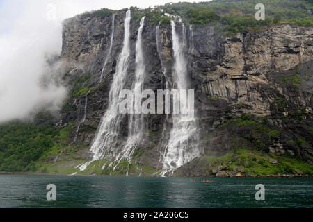 Kajak Entdecker an Sieben Schwestern Wasserfälle sourounded von mystischen Nebel, Geiranger Fjord in Norwegen. Stockfoto