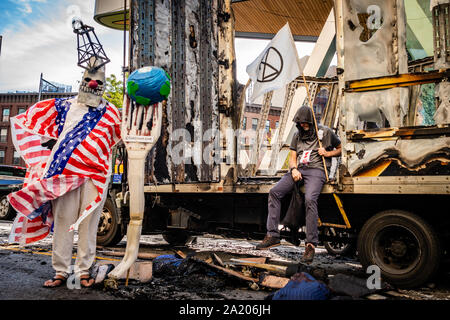 Brooklyn, Vereinigte Staaten. 29 Sep, 2019. Aussterben Rebellion Aktivisten posieren vor einem Ausgebrannten Umzugs-Lkw als Symbol der brennenden des Planeten. (Foto von Gabriele Holtermann-Gorden/Pacific Press) Quelle: Pacific Press Agency/Alamy leben Nachrichten Stockfoto