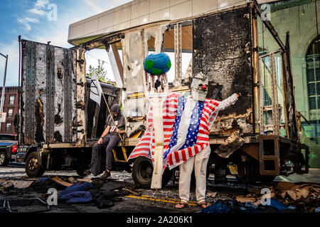 Brooklyn, Vereinigte Staaten. 29 Sep, 2019. Aussterben Rebellion Aktivisten posieren vor einem Ausgebrannten Umzugs-Lkw als Symbol der brennenden des Planeten. (Foto von Gabriele Holtermann-Gorden/Pacific Press) Quelle: Pacific Press Agency/Alamy leben Nachrichten Stockfoto