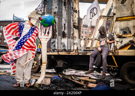 Brooklyn, Vereinigte Staaten. 29 Sep, 2019. Aussterben Rebellion Aktivisten posieren vor einem Ausgebrannten Umzugs-Lkw als Symbol der brennenden des Planeten. (Foto von Gabriele Holtermann-Gorden/Pacific Press) Quelle: Pacific Press Agency/Alamy leben Nachrichten Stockfoto