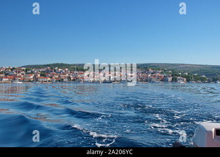 Segeln oder Motorboot auf der Adria mit Primosten Stadtbild im Hintergrund. Urlaub in Kroatien Stockfoto