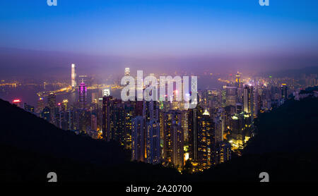 Ansicht von oben, atemberaubenden Blick auf die beleuchtete Skyline von Hongkong bei einem schönen Sonnenuntergang. Bild vom Victoria Peak. Stockfoto