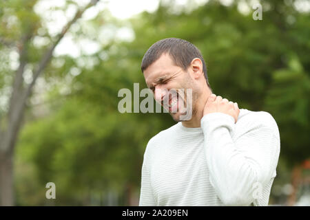 Der Mensch leiden Hals Schmerzen klagen allein in einem Park Stockfoto