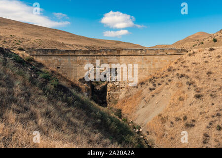 Alten baufälligen steinernen Brücke über einen kleinen Fluss Stockfoto