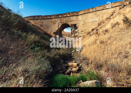 Alten baufälligen steinernen Brücke über einen kleinen Fluss Stockfoto