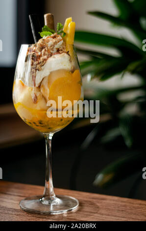 Bio Mango und Passionsfrucht tropische Eisbecher in Wein Glas Stockfoto