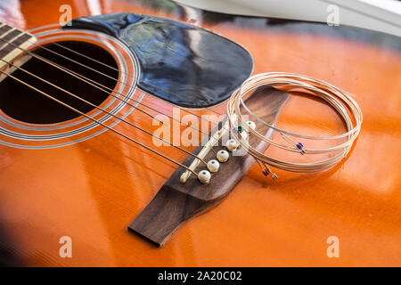 Neue Saiten auf der akustischen Gitarre bereit für Austausch Stockfoto