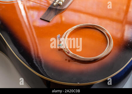 Neue Saiten auf der akustischen Gitarre bereit für Austausch Stockfoto