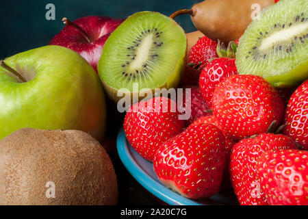 In der Nähe Bild von tropischen Früchten auf einem blauen Platte und einen dunkelblauen Hintergrund Stockfoto