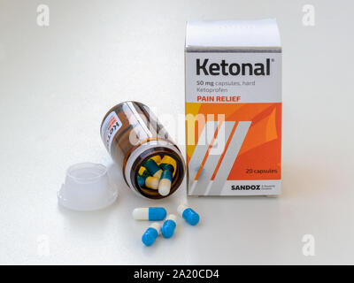 Varna, Bulgarien, 28. September 2019. Pain Relief pills Ketonal aus braunem Glas Glas in der Nähe von Pille Karton auf einem weißen Tisch verstreut. Health Care. Stockfoto