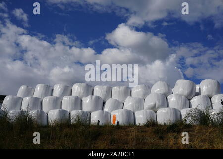 Stapel von Heuballen aus weißem Kunststoff in die Berge der Südlichen Alpen in Frankreich abgedeckt Stockfoto