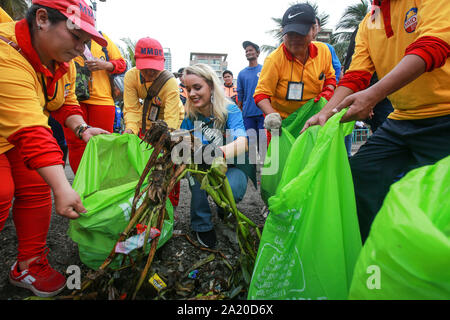 Manila, Sept. 30. 26 Okt, 2019. Eine Miss Earth 2019 Bewerber und Arbeitnehmer aus den Metropolitan Manila Development Authority (MMDA) sammeln Müll in der Bucht von Manila während einer Coastal cleanup in Manila, Philippinen, Sept. 30, 2019. Die Coastal cleanup ist Teil der Aktivitäten, die bis zur Miss Earth 2019 Krönung Nacht in Naga Provinz am Okt. 26, 2019. Credit: rouelle Umali/Xinhua/Alamy leben Nachrichten Stockfoto