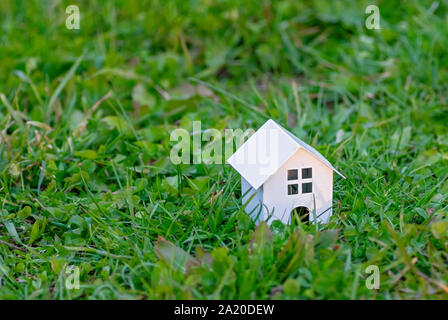 Holzspielzeug Haus auf dem Hintergrund der grüne Gras. Eco-freundliches Haus. Das Konzept eines Landhauses. Kopieren Sie Platz. Stockfoto