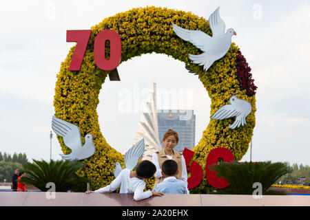 (190930) - DAQING, Sept. 30, 2019 (Xinhua) - eine Mutter und ihre Kinder posieren für ein Gruppenfoto am Iron Man Platz in Daqing im Nordosten der chinesischen Provinz Heilongjiang, Sept. 28, 2019. Daqing Oilfield, Sept. 26, 1959 entdeckt, ist das größte ölfeld von PetroChina und auch das größte Öl Produktionsbasis. Das Ölfeld, einmal die über die Hälfte des Chinesischen insgesamt ausgegeben, Rohöl Rohöl hatte eine jährliche Produktion von über 50 Millionen Tonnen für 27 Jahre und mehr als 40 Millionen Tonnen für 12 gerade Jahre. Seine jährliche Rohöl und Gas Ausgang bleibt noch über 40 Stockfoto