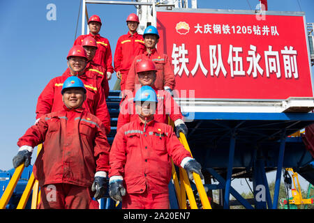 (190930) - DAQING, Sept. 30, 2019 (Xinhua) - Mitarbeiter der Nr. 1205 bohren Team posieren für ein Gruppenfoto auf einer Bohrinsel in Daqing Oilfield in Daqing im Nordosten der chinesischen Provinz Heilongjiang, Sept. 28, 2019. Daqing Oilfield, Sept. 26, 1959 entdeckt, ist das größte ölfeld von PetroChina und auch das größte Öl Produktionsbasis. Das Ölfeld, einmal die über die Hälfte des Chinesischen insgesamt ausgegeben, Rohöl Rohöl hatte eine jährliche Produktion von über 50 Millionen Tonnen für 27 Jahre und mehr als 40 Millionen Tonnen für 12 gerade Jahre. Seine jährliche Rohöl und Gas o Stockfoto