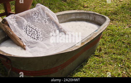 Eine altmodische Waschen trougth ein Jahrgang kind Stuhl, und hölzerne Schiffe Wasser zu bringen Stockfoto