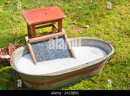 Eine altmodische Waschen trougth ein Jahrgang kind Stuhl, und hölzerne Schiffe Wasser zu bringen Stockfoto