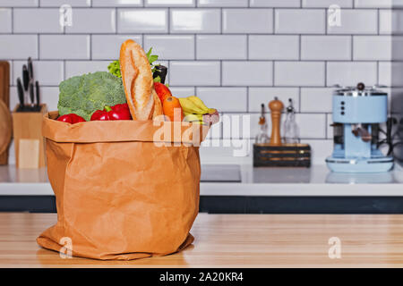 Papiertüte voller Frische Produkte aus voller Frische Produkte vom Lebensmittelgeschäft oder Supermarkt stehen auf hölzernen Tisch Stockfoto