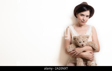 Junge attraktive Frau umarmen Teddybär Stockfoto