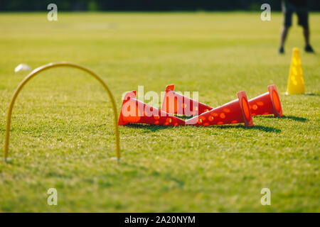 Fußball Fußball-Training Ausrüstung auf Training. Fußball Kegeln und Ziel am Fußballplatz. Trainer und junge Fußballer im Hintergrund. Coachin Stockfoto