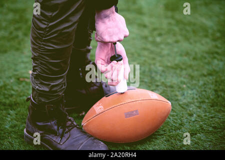 Nahaufnahme der Mann auf dem Feld pumpt Luft in eine Professionelle ball für American Football Stockfoto