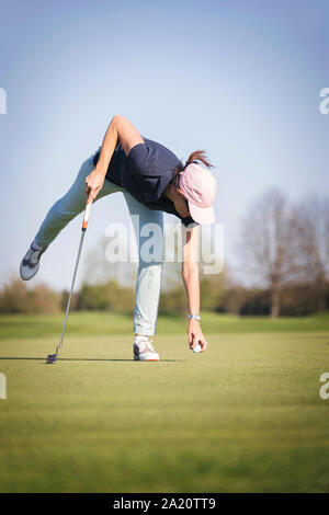 Frau Golf player Pick up Kugel. Stockfoto