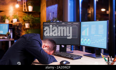 Geschäftsmann, schlafen mit dem Kopf auf den Tisch im Büro. Mondlicht und müde Boss Stockfoto