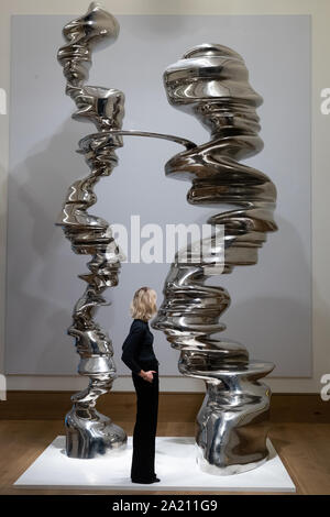 Eine Gallery Assistant beobachtet Tony Craggs Skulptur ständigen Wandel, 2005, während einer Pressekonferenz bei Bonhams New Bond Street, London, vor der Versteigerung bei Bonhams' der Nachkriegszeit und Zeitgenössische Verkauf am 3. Oktober. Die Edelstahl, 4,5 m hohe Skulptur wird voraussichtlich zwischen? abrufen??? 450.000 - 600.000. Stockfoto