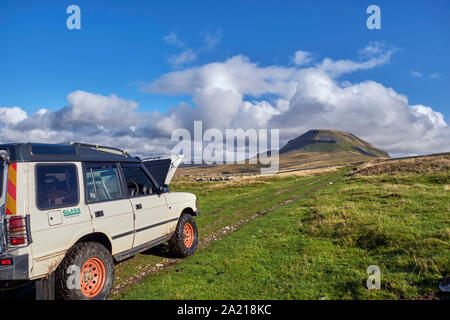 Auto mit Motorhaube auf unbefestigten Straßen in der Nähe von Helwith Brücke mit Pen y Gent darüber hinaus. Yorkshire Dales National Park, England. Stockfoto