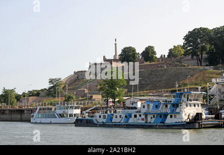 Schwimmendes Restaurant und Bar Boot wie auf den Zusammenfluss von Save und Donau mit dem Pobednik (Victor) Statue Denkmal in der kalamegdan Park im Hintergrund, Belgrad, Serbien gesehen. Stockfoto