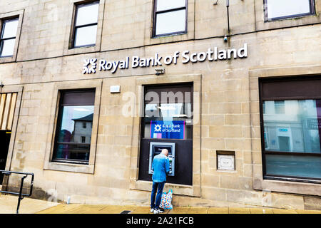 Mann mit Royal Bank of Scotland cashpoint Maschine, Berwick upon Tweed, Northumberland, Großbritannien, England, ATM, Geldautomat, Royal Bank of Scotland, logo Stockfoto